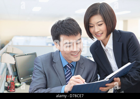 Zwei Geschäftsleute, die im Notizbuch Stockfoto