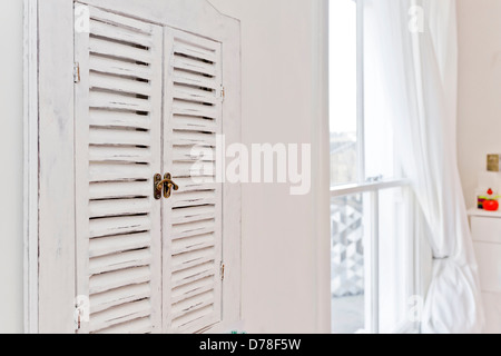 Distressed Schrank Fensterläden und Schiebefenster in modernen weißen Raum Stockfoto