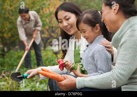 Glückliche Familie Ernte Gemüse im Garten Stockfoto