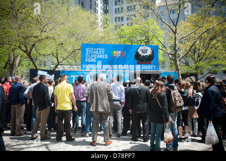 Glücklich Eishockey-Fans und andere Besucher erhalten kostenlose Werbe Cupcakes im Madison Square Park in New York Stockfoto