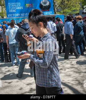 Glücklich Eishockey-Fans und andere Besucher erhalten kostenlose Werbe Cupcakes im Madison Square Park in New York Stockfoto