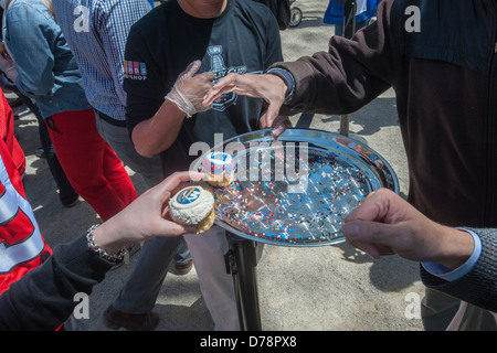 Glücklich Eishockey-Fans und andere Besucher erhalten kostenlose Werbe Cupcakes im Madison Square Park in New York Stockfoto