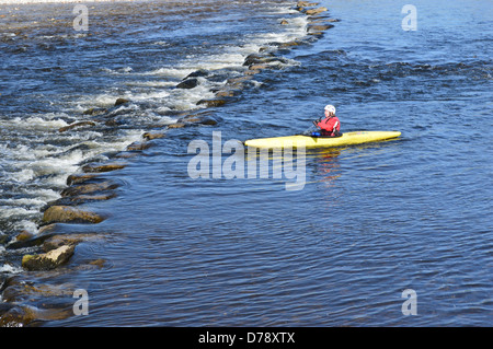 Einzelne Kanute nähert sich die Stepping Stones über Flusses Wharfe im Linton in der Nähe der Dales so Long Distance Wanderweg Stockfoto