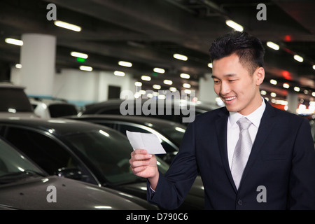 Reisende auf der Suche bei Ticket auf Flughafen-Parkplatz Stockfoto
