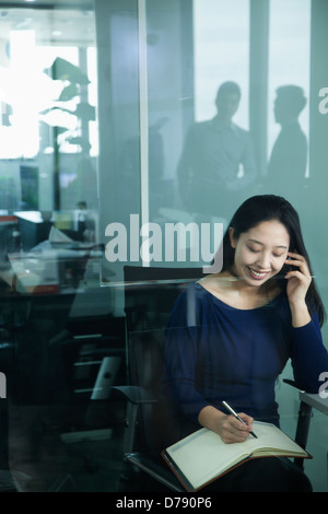 Geschäftsfrau am Telefon im Büro Stockfoto