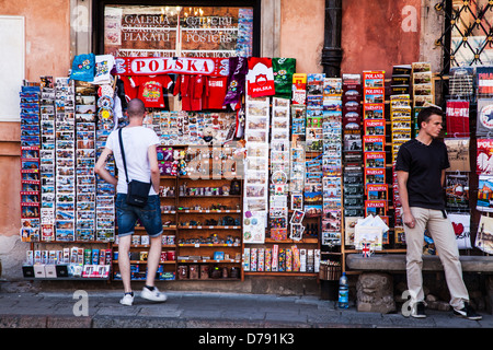 Ein Tourist schaut auf eine Postkarte und Souvenir Stall in Stary Rynek, alte Stadt-Marktplatz in Warschau, Polen. Stockfoto