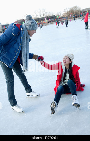 Junges Paar auf Eisbahn Stockfoto