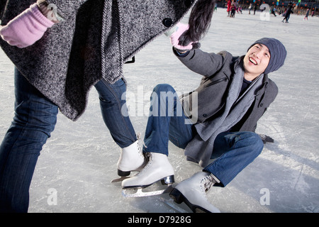 Junges Paar auf Eisbahn Stockfoto