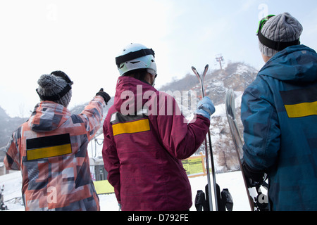 Gruppe von Menschen, die auf Hügel im Skigebiet Stockfoto