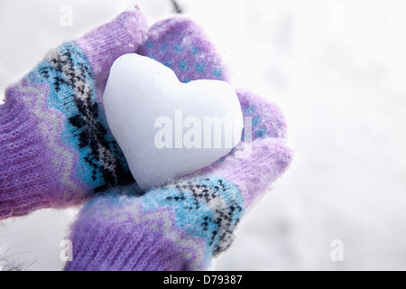 Schnee-Herz in die Hände mit Handschuhen Stockfoto
