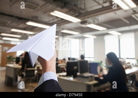 Hand, die Papierflieger im Büro Stockfoto