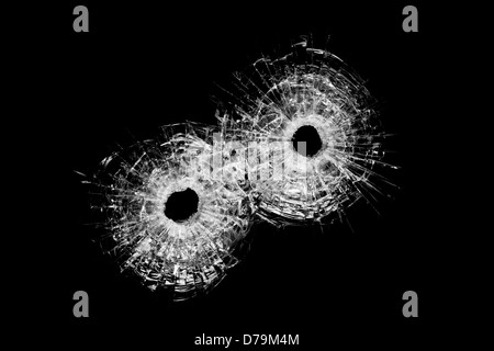 Einschusslöcher in Glas - authentische Kugel Löcher Nahaufnahme isoliert auf schwarz Stockfoto