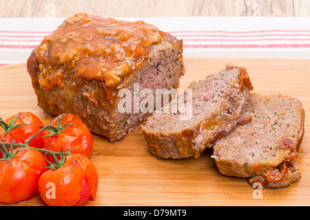 Frisch gebackene Hackbraten mit einer Tomaten-Glasur auf einem Holzbrett - Studio gedreht Stockfoto