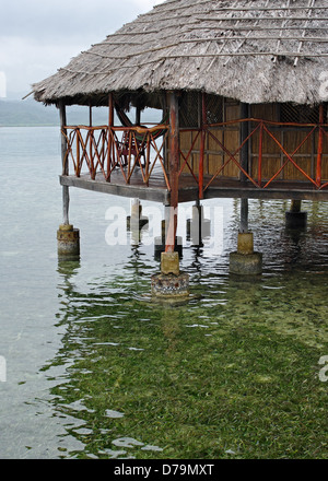 Eine strohgedeckte Hütte über Wasser in Kuna Yala in der Republik Panama. Stockfoto