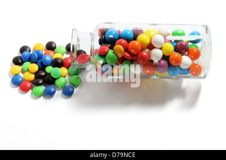 Glasflasche mit Schokolinsen Stockfoto
