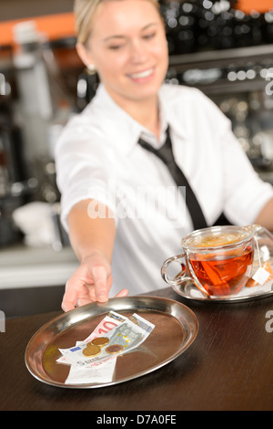 Attraktive Kellnerin Einnahme Tipp in der Bar vom Fach Euro Stockfoto