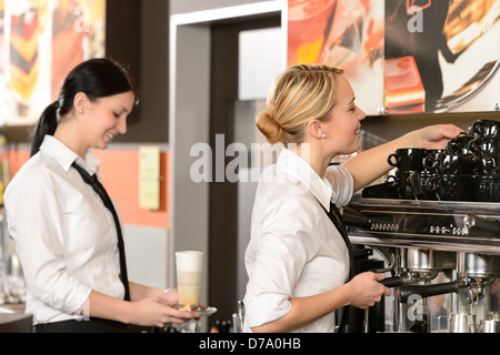 Zwei Kellnerinnen serviert Kaffee mit Maschine im shop Stockfoto