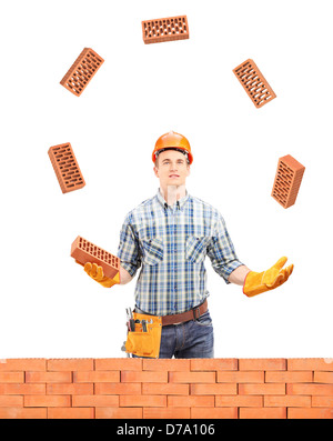 Bauarbeiter, Jonglieren mit Steinen hinter eine Mauer, isoliert auf weißem Hintergrund Stockfoto