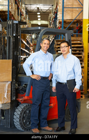 Porträt von Geschäftsleuten mit Gabelstapler im Lager Stockfoto