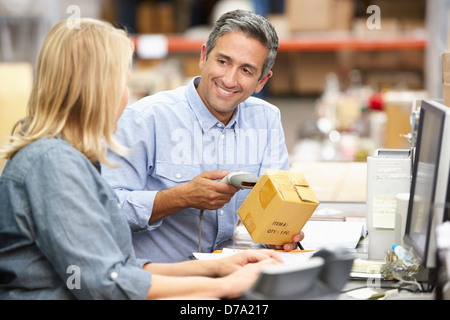 Kollegen arbeiten am Schreibtisch im Lager Stockfoto