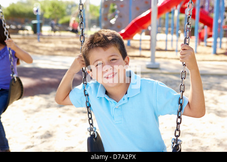 Junge auf Schaukel im Park Stockfoto