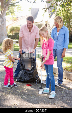 Familie Abholung Wurf In Suburban Street Stockfoto