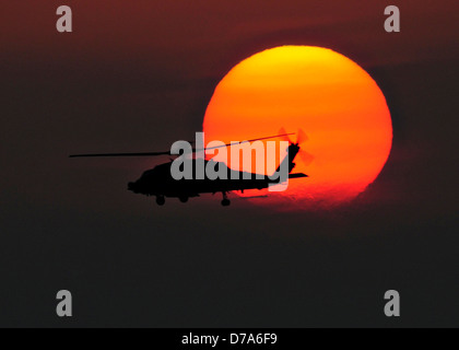 Ein Marine HH - 60H Seahawk-Hubschrauber fliegt über das Flugdeck des Flugzeugträgers USS Dwight D. Eisenhower bei Sonnenuntergang bei Operationen zur Unterstützung des Afghanistan-Krieges 29. April 2013 in North Arabische Meer. Stockfoto