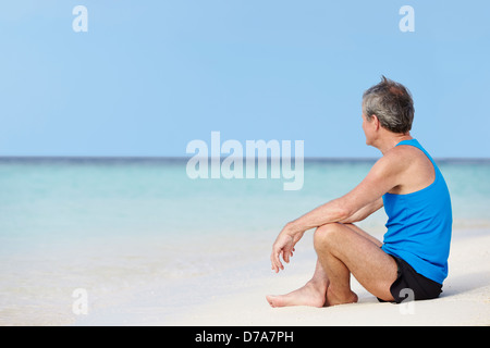 Senior Woman In Sportbekleidung, relaxen am Strand Stockfoto
