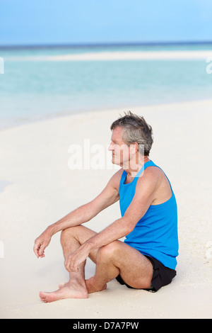 Senior Woman In Sportbekleidung, relaxen am Strand Stockfoto