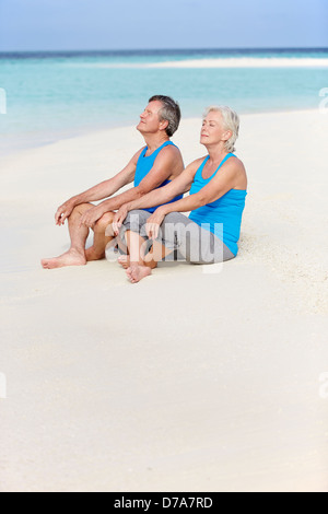 Älteres paar In Sportbekleidung, relaxen am Strand Stockfoto