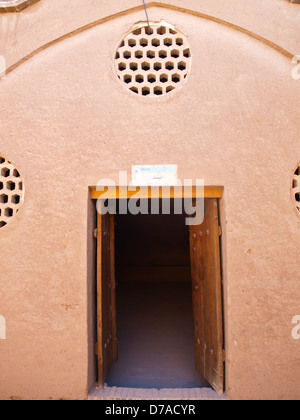 Lüftung-Lamelle und Holztür in der Adobe-Architektur der Küche im historischen Altbau in Kashan, Iran Stockfoto