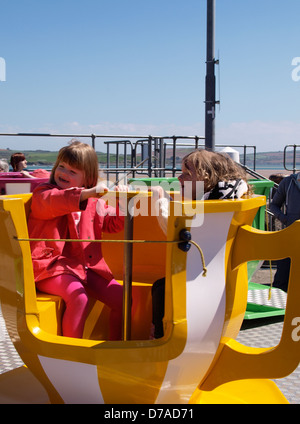 Zwei junge Mädchen auf eine Teetasse zu fahren, am Festplatz, UK 2013 Stockfoto