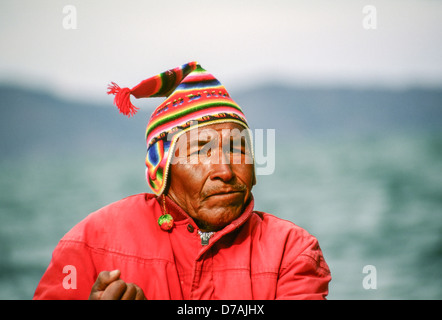 Ein Fährmann am Titicaca-See, an den Grenzen von Bolivien und Peru, mit bunten Kopfbedeckungen Stockfoto