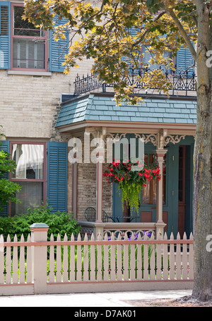 Blüten hängen auf einer Veranda eines viktorianischen Hauses in Cedarburg, Wisconsin. Stockfoto