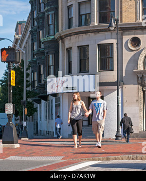 Fußgänger überqueren eine Straße vor einem Steingebäude in Boston. Stockfoto