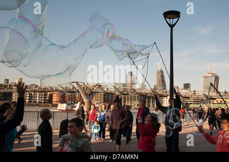 London, England UK 2. Mai 2013. Straßenkünstler Schlag riesige Seifenblasen am Südufer der Themse. Bildnachweis: Patricia Phillips / Alamy Live News Stockfoto