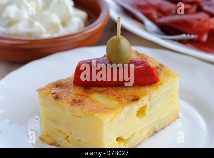 Spanische Tortilla, garniert mit Paprika und grünen Oliven Tapas, Andalusien, Spanien. Stockfoto