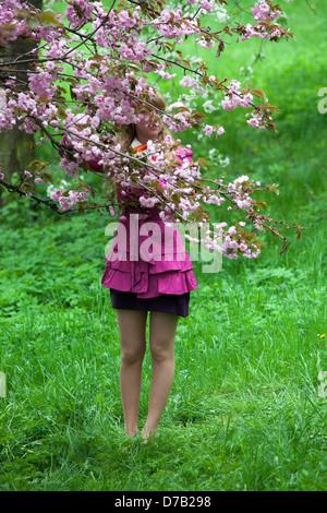 Ein romantischer Spaziergang auf Petrin Hill, Cherry, Petrin Gardens Prag Tschechische Republik Frau gesichtslos Natur grüne Szene lila Anzug kurzer Rock Stockfoto