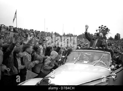 Begeisterter Empfang für den deutschen Internatinoal Spieler Max Morlock (rechts) im Nürnberger Stadion am 7. Juli 1954 vor 30.000 Zuschauern. Morlock winkt an junge Studenten aus dem hinteren Auto. Die deutsche Fußball-Nationalmannschaft mit Morlock hatte sensationell gewann 1954 FIFA World Cup-Finale 3:2 gegen Ungarn zum ersten Mal einen WM-Titel zu gewinnen. Beliebte Angreifer Morlock erzielte das 1:2-Reduzierstück. Stockfoto