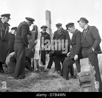 Fast alle Gräber auf Helgoland werden zerstört. Daher diese Menschen legen Blumen nieder am 1. März 1952 an das einfache Holzkreuz, das im Namen aller verstorbenen gebaut wurde. An diesem Tag wurde die Insel Helgoland zurück nach Deutschland durch die britische Regierung begangen, nachdem es eine verbotene, Todeszone und eine Bombe Exerzierplatz der britischen Luftwaffe nach der Bombardierung im zweiten Weltkrieg wurde und eine schwere Strahlen. Stockfoto