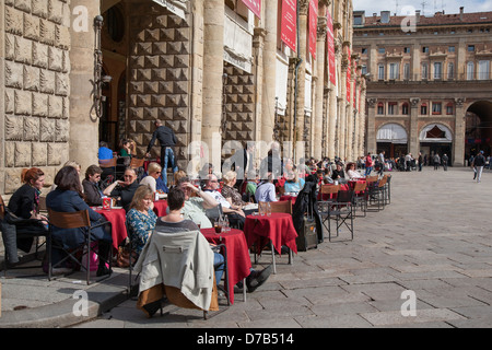 Leute sitzen im Cafe Tische draußen den Palazzo del Podestà Palast in der Piazza Maggiore - Hauptplatz in Bologna; Italien Stockfoto