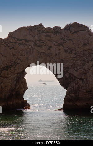 Ein Motorboot und ein Tanker sichtbar durch Durdle Door auf der SW Heritage Coast, Dorset, England, UK Stockfoto