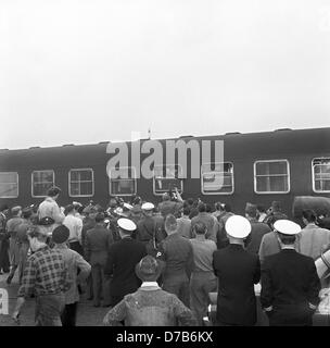 Elvis Presley (im Zug, Fenster, R) Wellen aus einem Zugabteil an seine Fans am Bahnhof Bremerhaven am 1. Oktober 1958. Presley und andere US-Soldaten hatte gerade mit der US-Truppentransporter "General Randall" in Bremerhaven angekommen. Der amerikanische Rock ' n Roll Sänger war als Soldat in der 3. US-Panzerdivision in Friedberg (Hessen) im Rahmen seines Militärdienstes in der US Army in den 1950er Jahren stationiert. Stockfoto