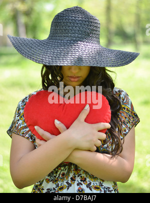 Porträt eines Mädchens mit großen roten Herz im freien Stockfoto