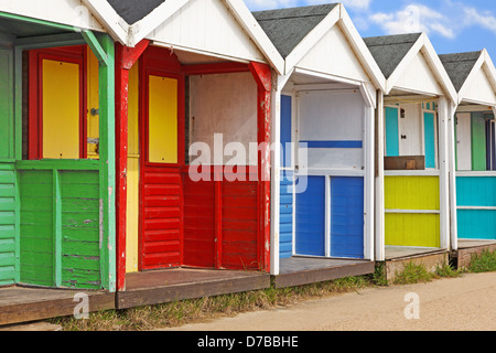 Eine Zeile verwitterte alte bunte hölzerne Strandhütten. Stockfoto