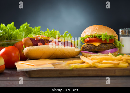 Käse-Burger und Hot Dogs mit viel Fast Food Zutaten auf dem Hintergrund Stockfoto