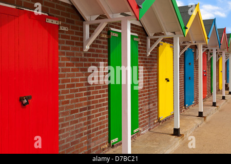 Mehrfarbige Strandhütten in Folge an einem sonnigen Tag. Stockfoto