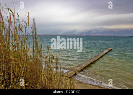 Meer Wellen aus Holz Boardwolk in Sabunike, Dalmatien, Kroatien - mit nebligen Velebit-Hintergrund Stockfoto