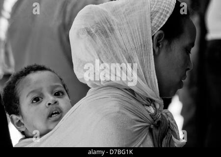 Jerusalem, Israel. 3. Mai 2013. Eine christliche Afrikanerin hält ihr Baby auf den Rücken geschnallt, wie sie wartet in der Kirche des Heiligen Grabes auf Heilige und große Freitag dürfen. Jerusalem, Israel. 3. Mai 2013.  Tausende von östliche orthodoxe Christen nehmen an Crucessions entlang der Via Dolorosa, Rückverfolgung der letzten Schritte von Jesus am Heiligen und großen Freitag, vorhergehenden Ostern Teil. Emotionen Höhepunkt auf Annäherung an die Kirche des Heiligen Grabes. Bildnachweis: Nir Alon / Alamy Live News Stockfoto