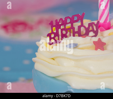 Happy Birthday Cupcake mit weißem Zuckerguss blau Gehäuse und rosa Kerze Stockfoto